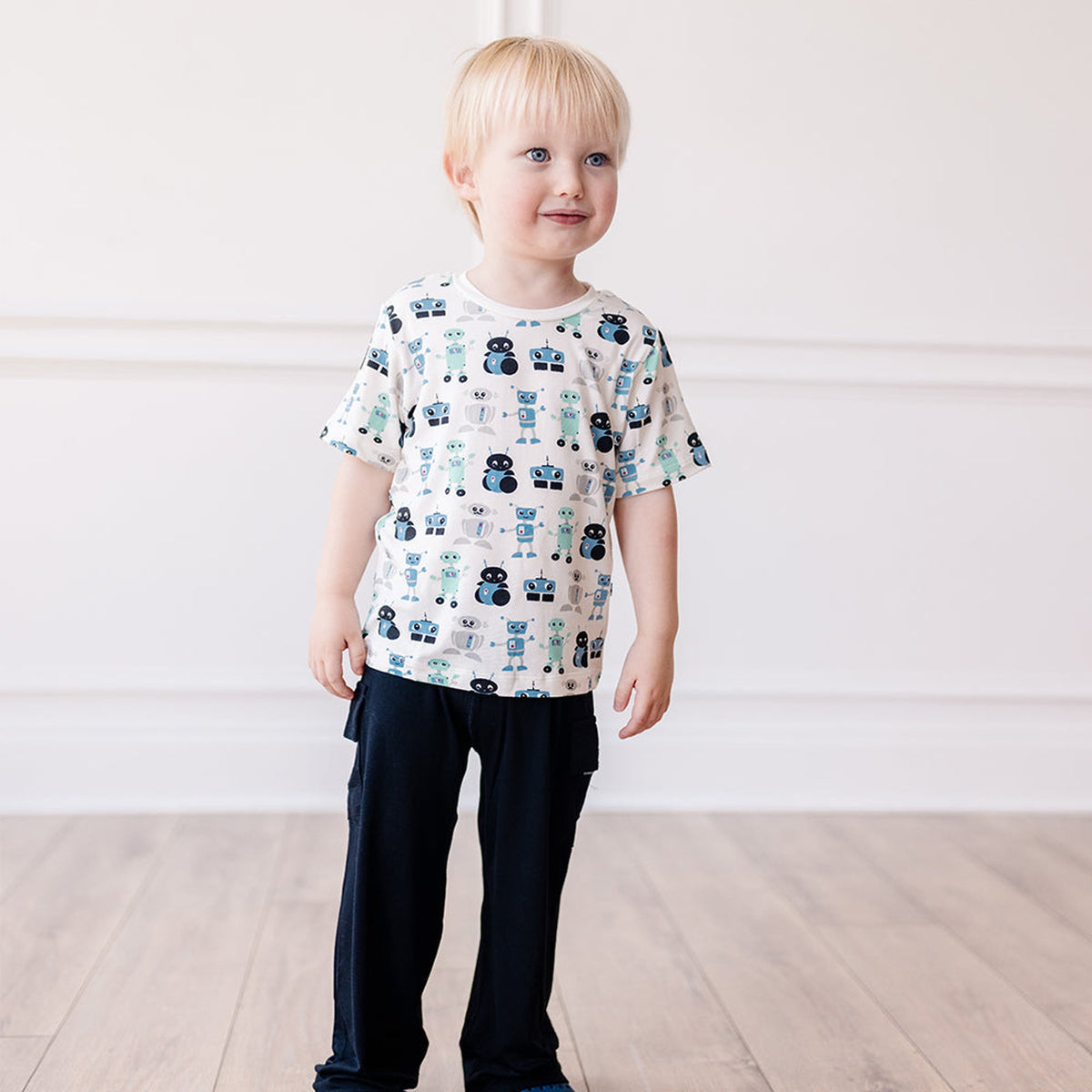 ロボット柄の半袖クルーネックTシャツと濃色パンツの着用全身