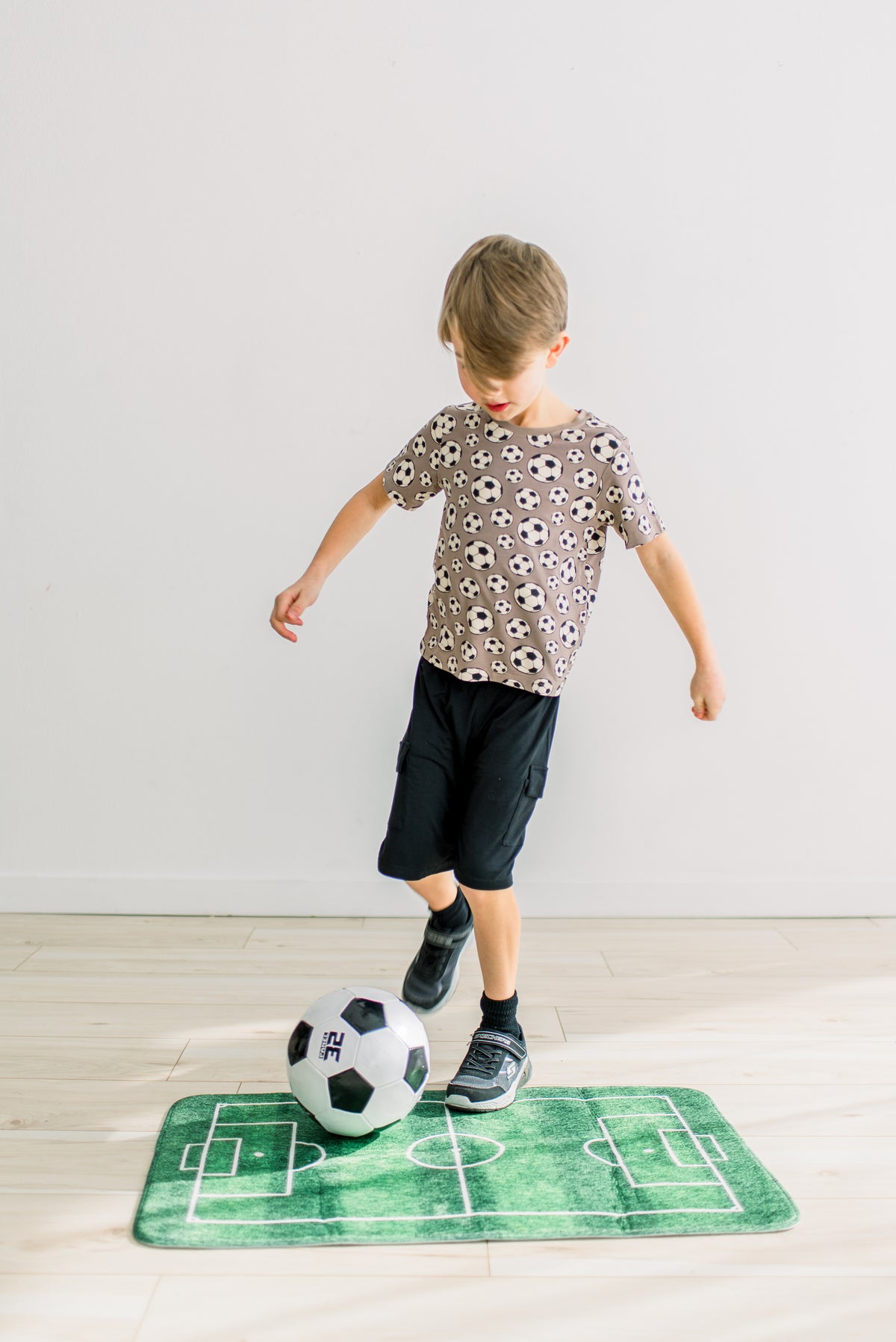 Portabella Soccer柄の半袖クルーネックTシャツを着てボールで遊ぶ子ども