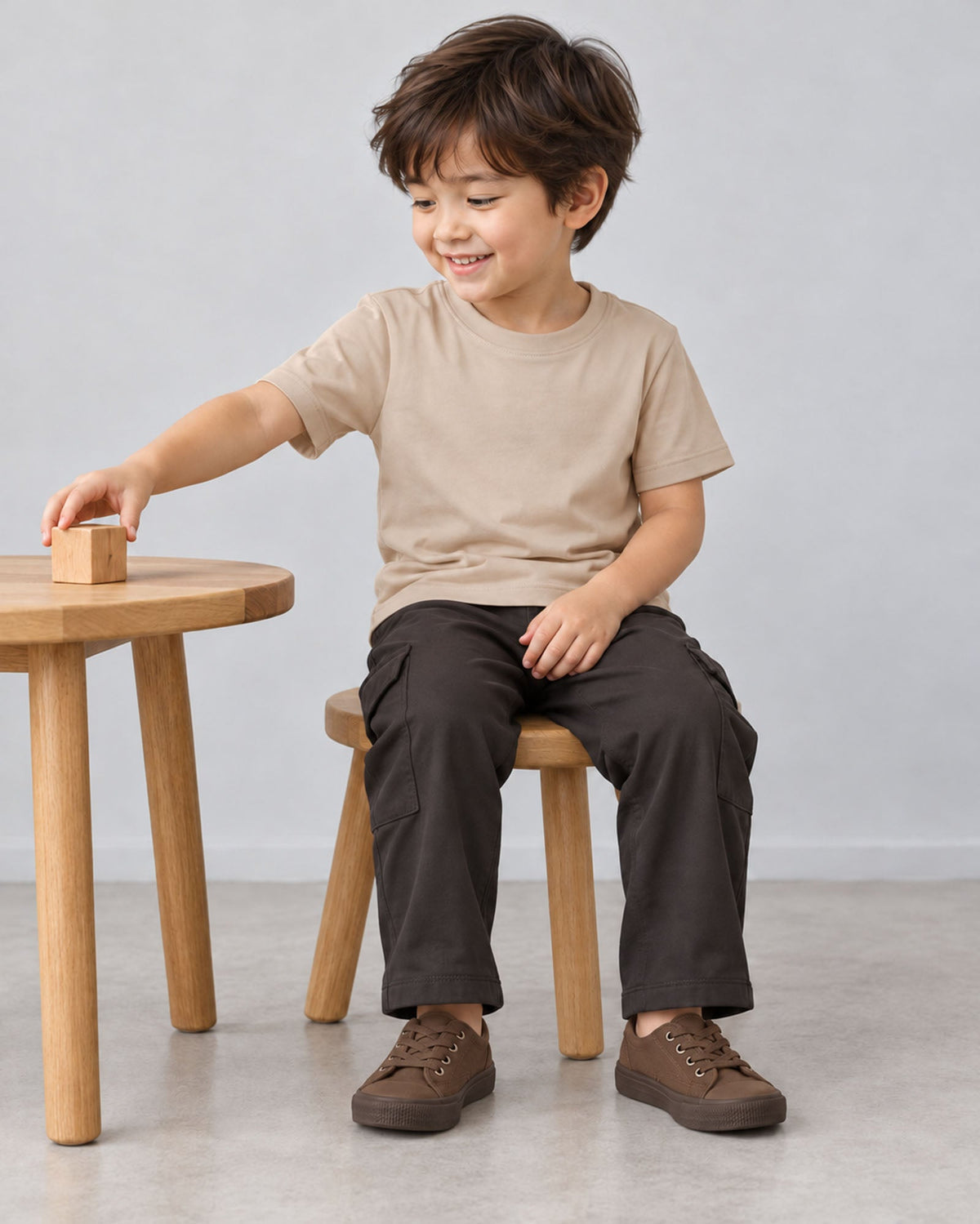 Burlapの半袖クルーネックTシャツを着て、椅子に座り木の積み木で遊ぶモデル