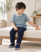 Fresh Air Wavesの波柄半袖クルーネックTシャツを着て、ベンチに座り木の積み木で遊ぶモデル