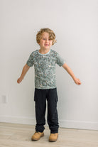 Spring Sky Tinkering柄の半袖クルーネックTシャツを着て両腕を広げる子ども