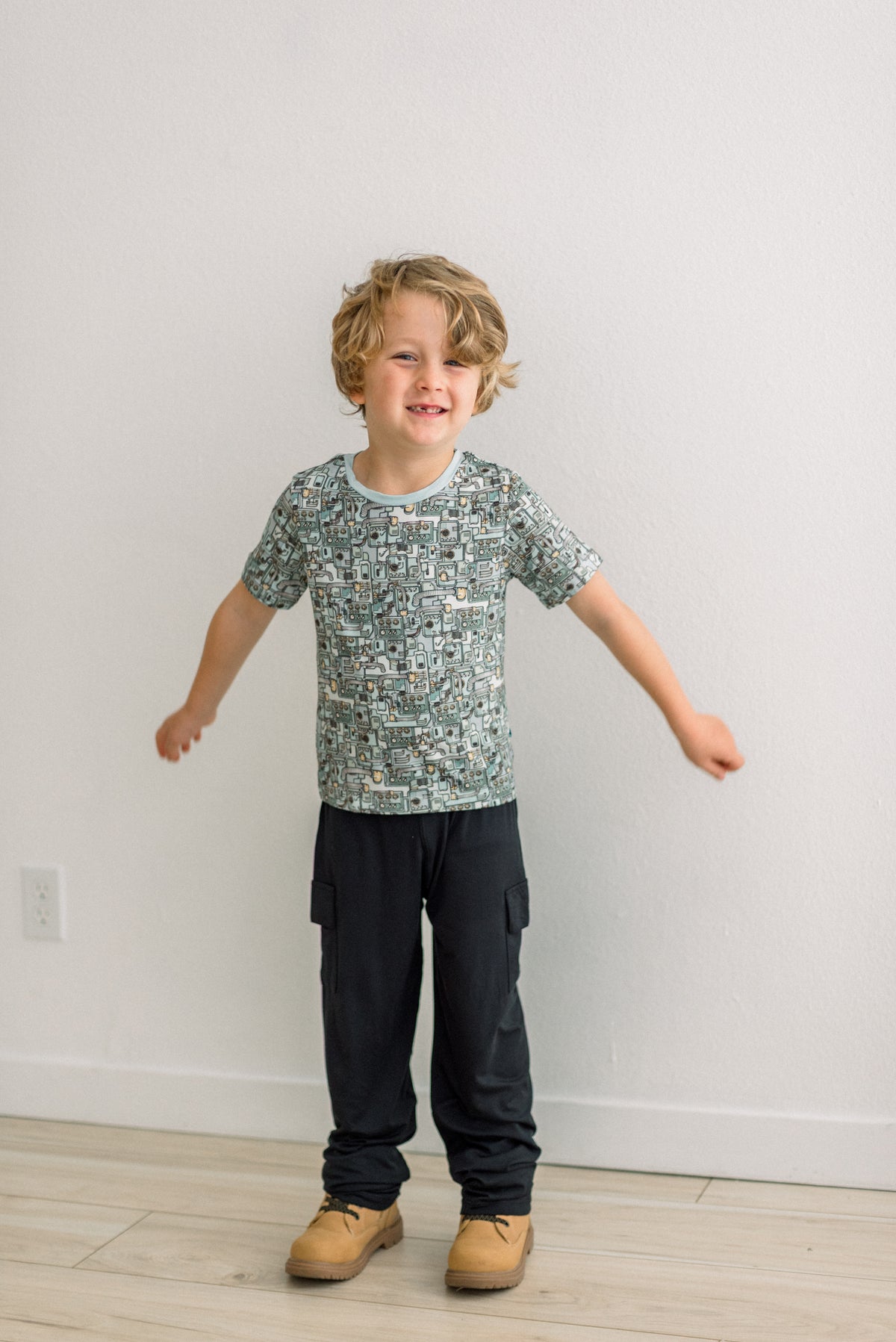 Spring Sky Tinkering柄の半袖クルーネックTシャツを着て両腕を広げる子ども